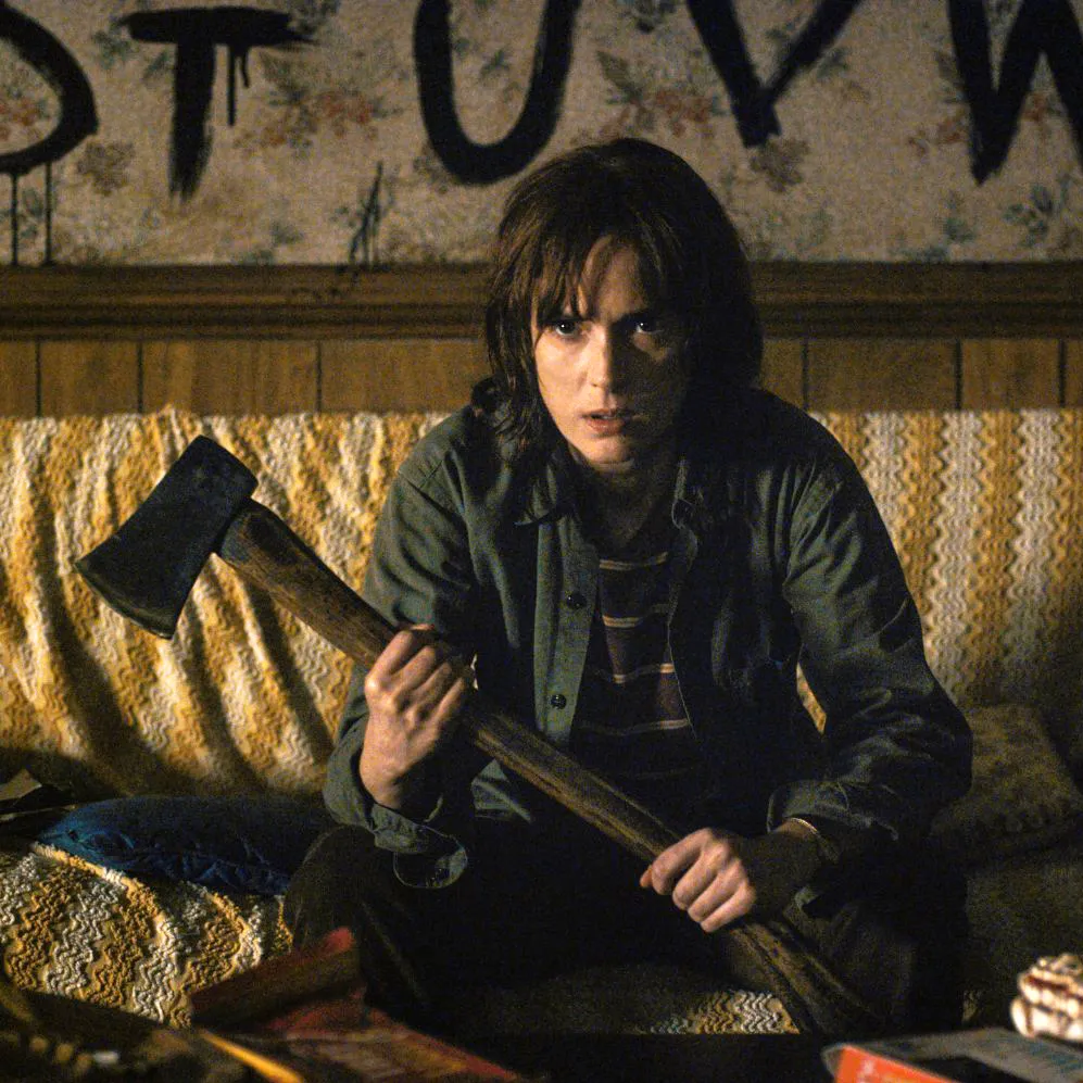 Winona Ryder as Joyce Byers in Stranger Things, holding an ax.