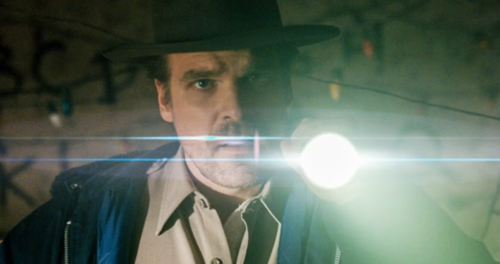 David Harbour as Jim Hopper holding a flashlight.
