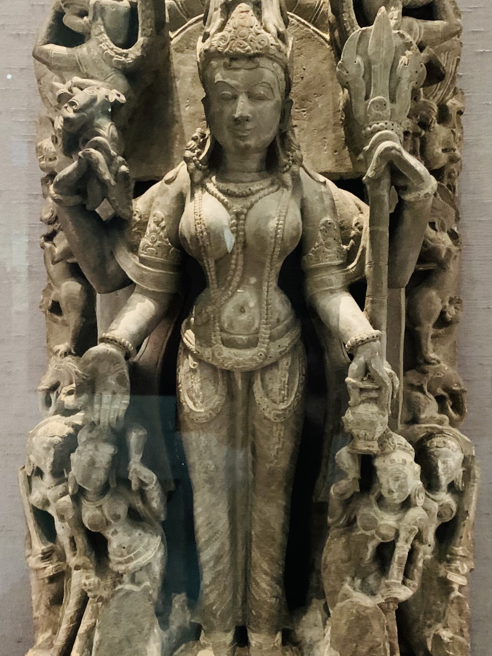 A stone sculpture of the goddess Parvati holding a trident and rosary.